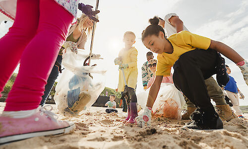 Kids picking up trash on a beach