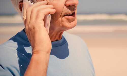 Man using cell phone at the beach