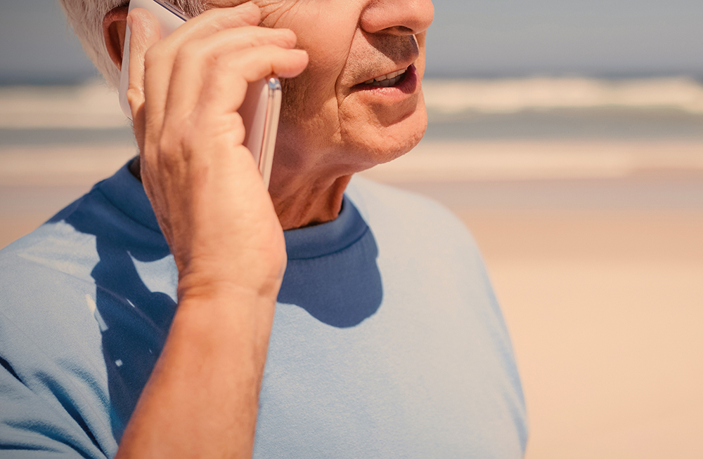 Man using cell phone at the beach